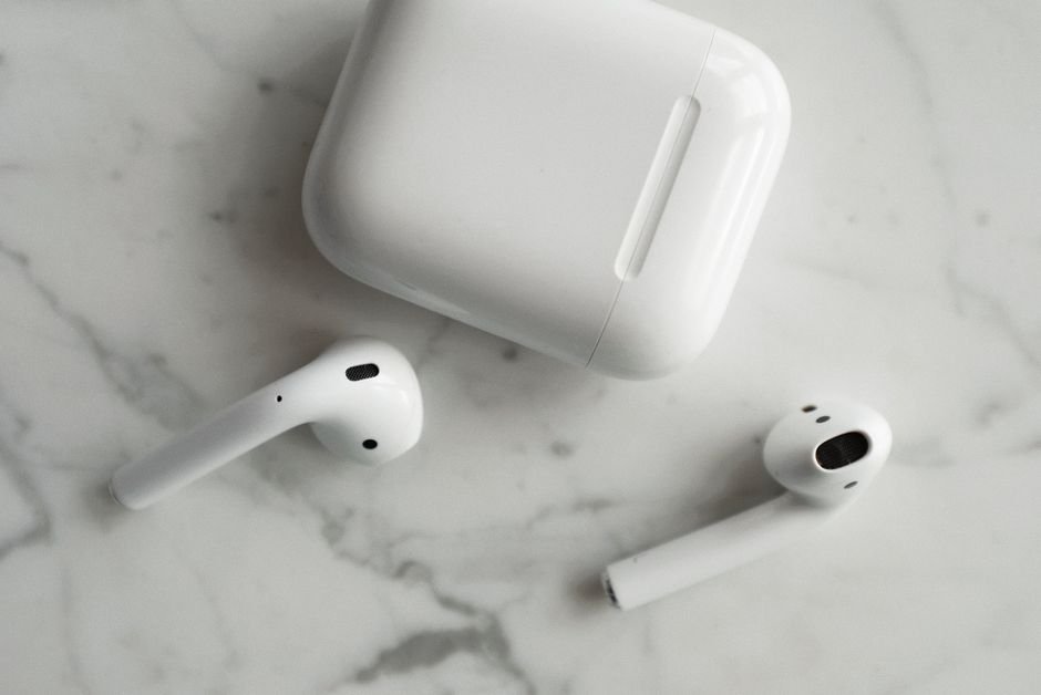 Pair of sleek modern wireless earbuds with compact charging case on marble surface