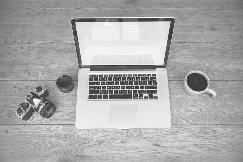 Minimalist creative desk with laptop and camera equipment for content creation