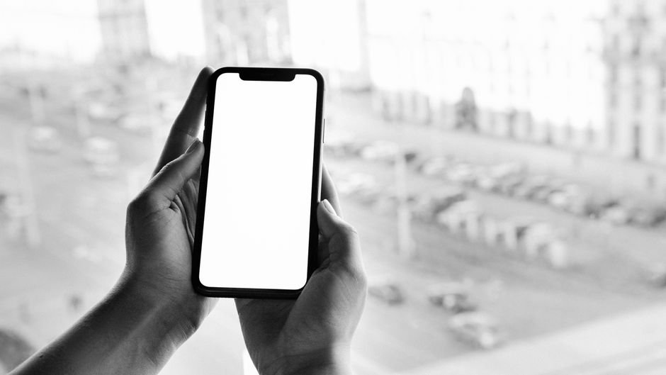 Handheld smartphone operating on cellular data against an urban backdrop