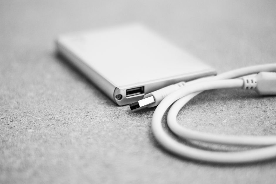 Compact external hard drive on desk used for cold secondary data storage