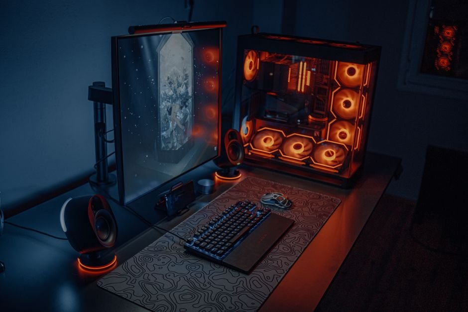 High performance RGB gaming desktop battle station next to gaming laptop