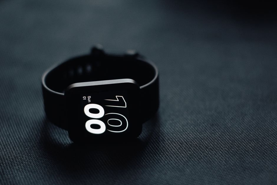 High resolution circular smartwatch dial displaying time and workout widgets on table