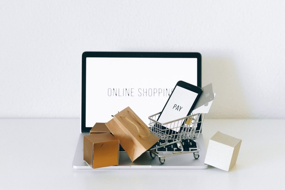 Miniature shopping cart resting on keyboard representing festive e-commerce sales and discount checkout