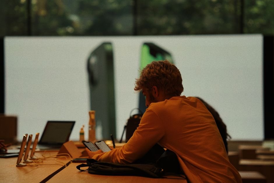 Customer testing smartphones and electronic gadgets inside modern tech retail store