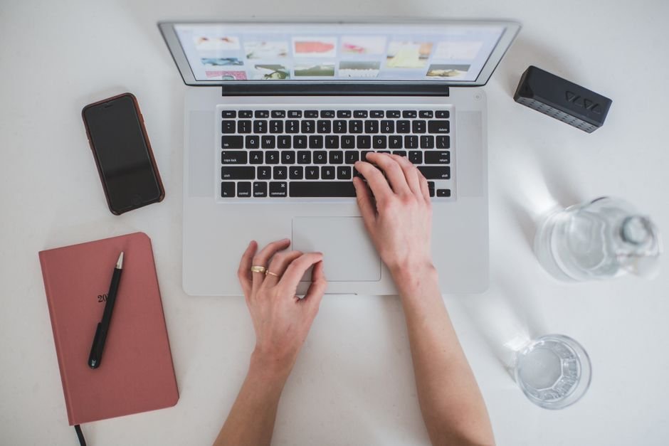Overhead view of author keyboard and paper notebook outlining blog content structure