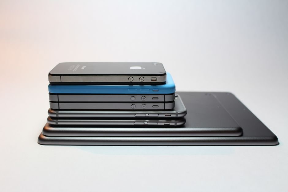 Modern smartphone placed next to expansive tablet display on wooden surface