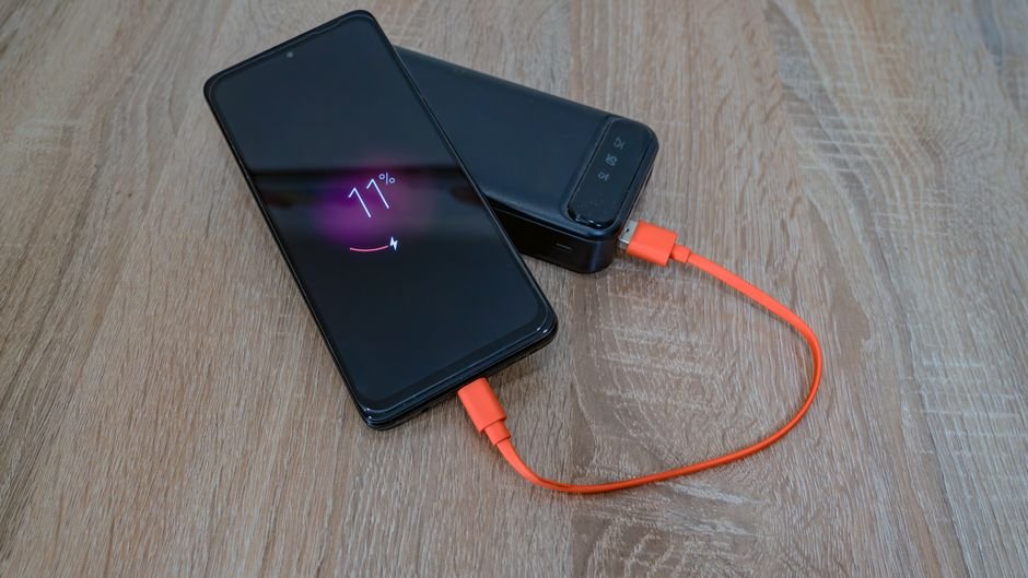 Modern high capacity portable power bank charging a smartphone with fast charging cable