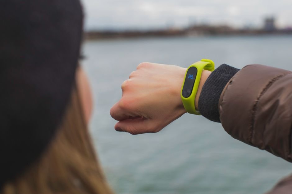 Active person outdoors checking fitness metrics on a modern smartwatch wrist display