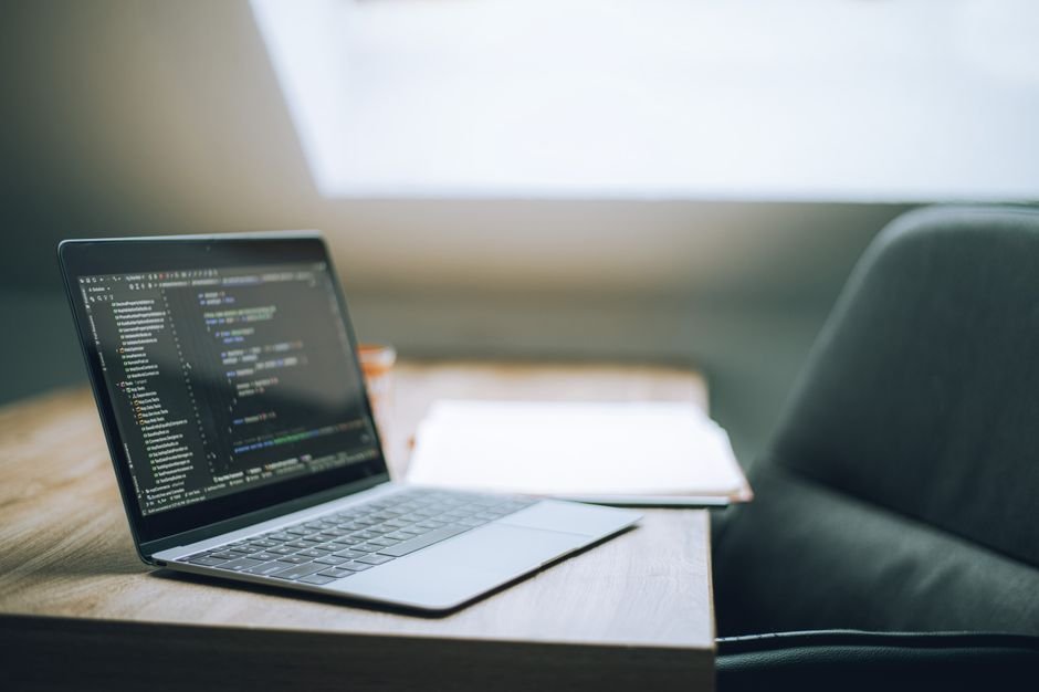Laptop screen running programming environment in bright modern workspace