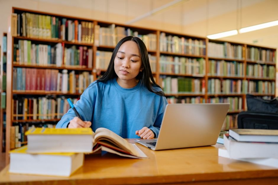 Student typing research notes on a lightweight notebook in university library