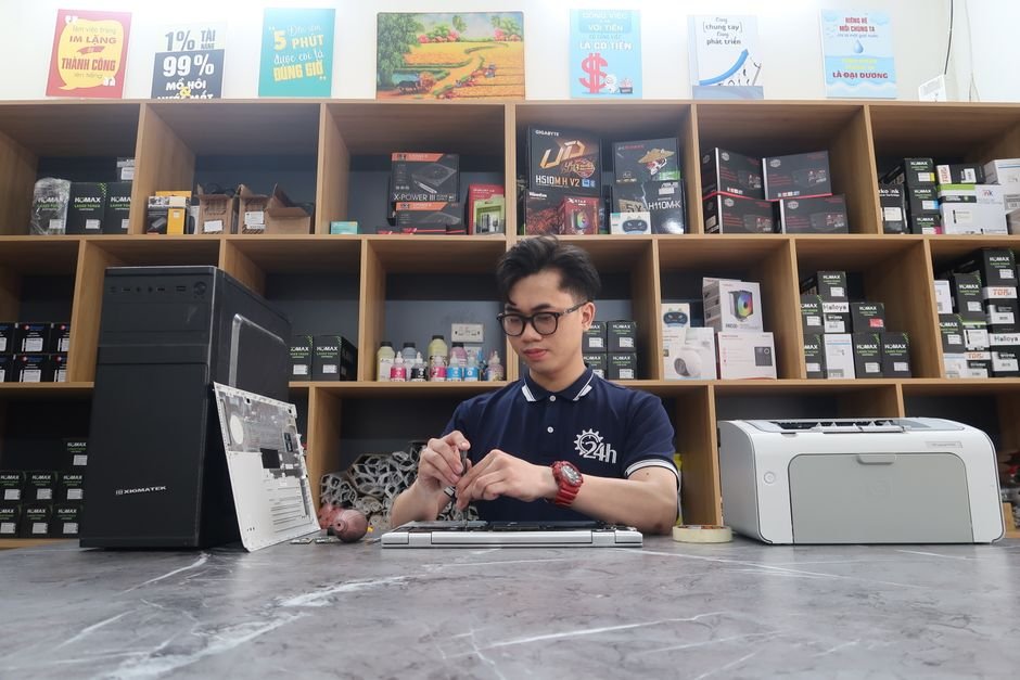 Certified electronics repair technician diagnosing laptop motherboard inside authorized service center